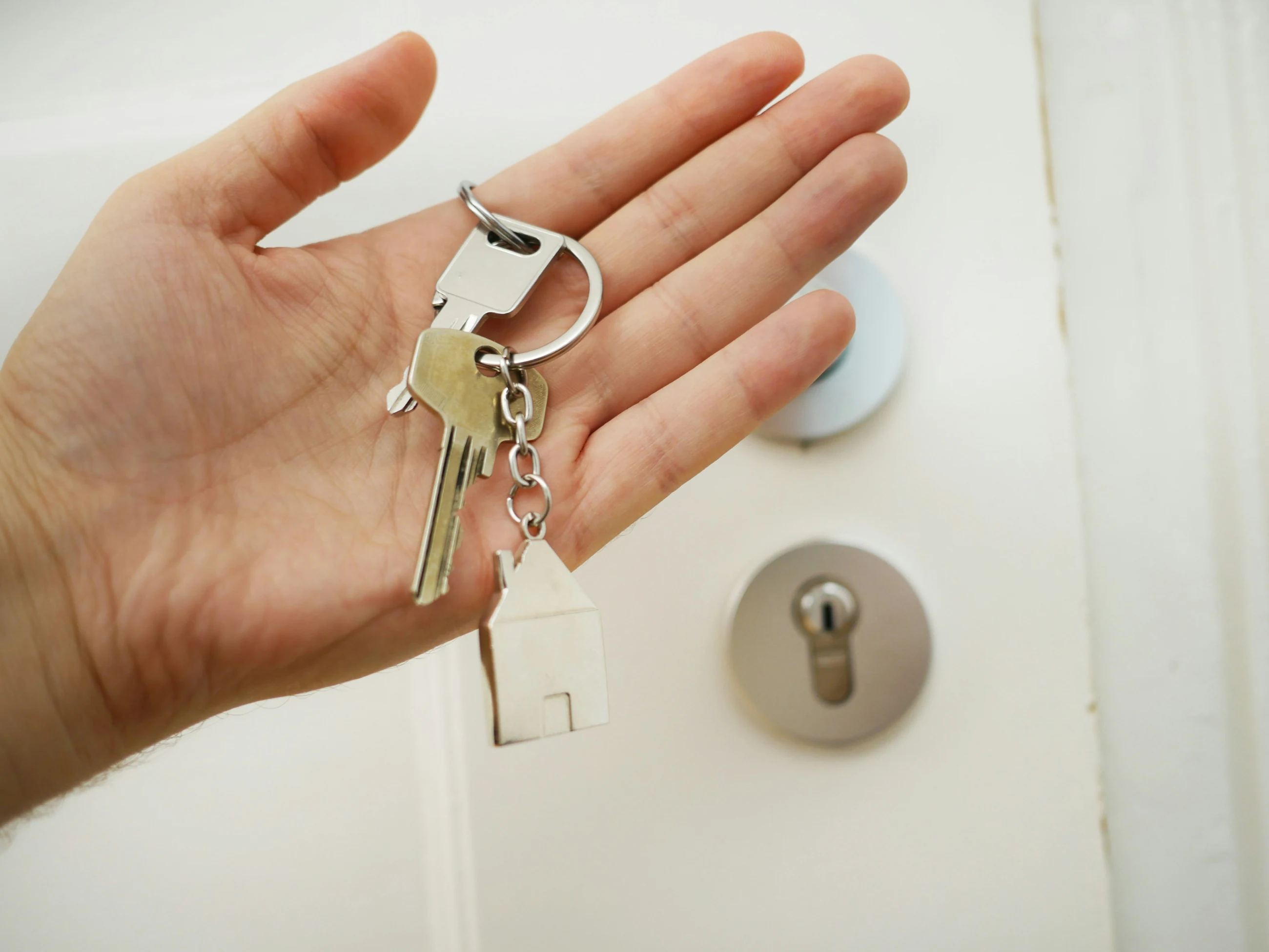 A hand holding the keys to a new home